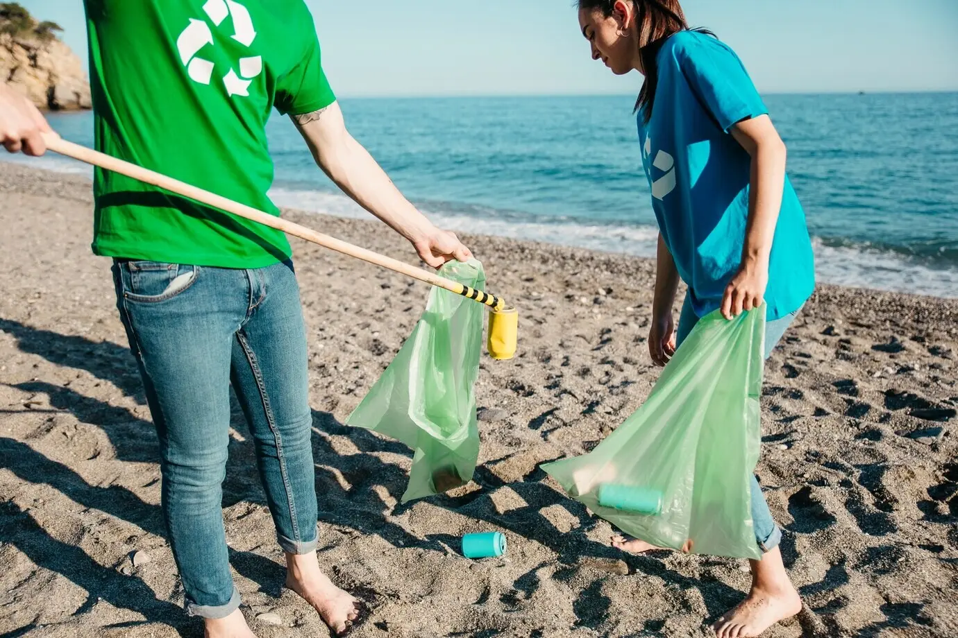 Dos voluntarios recogiendo basura en la playa